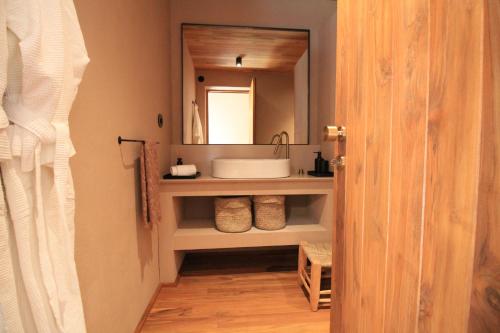 een badkamer met een wastafel en een spiegel bij Vinha by NHôme in Ponte de Lima