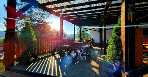 a patio with a table and chairs and the sun shining at Penzion Stavař in Vrbno pod Pradědem