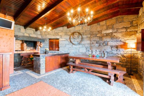 a kitchen with a wooden table and a stone wall at Villa Valeriu in Santa Cruz