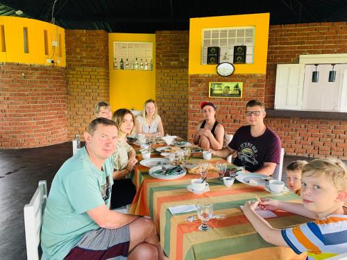 a group of people sitting around a table in a restaurant at Sethway Village in Minneriya