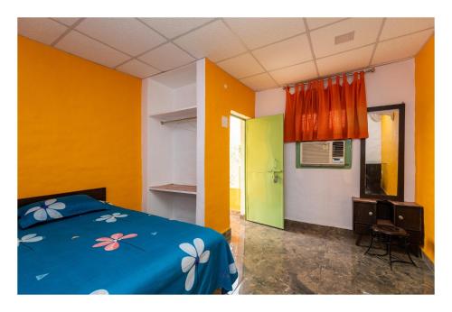 a bedroom with a blue bed and orange walls at An Authentic Village Farm in Jhānsi