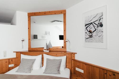 a bedroom with a mirror and a bed with pillows at Das Stadthaus in Neusiedl am See