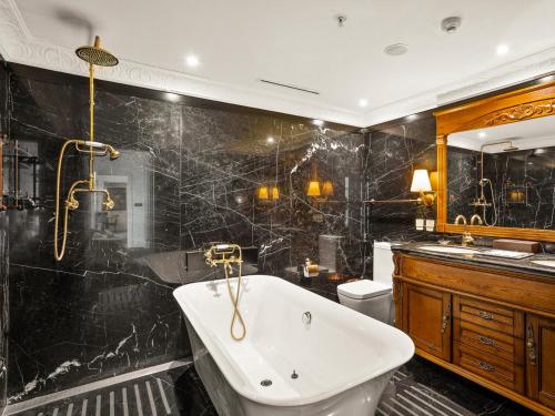 a bathroom with a tub and a toilet and a sink at The Terrace Hotel in Perth