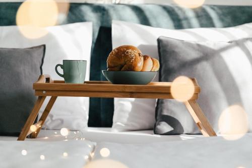 a tray of bread and a cup of coffee on a bed at Das Stadthaus in Neusiedl am See