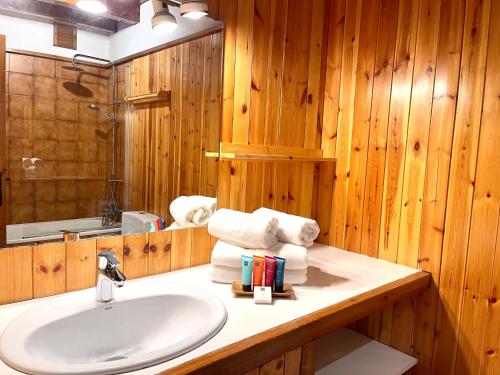 ein Bad mit einem Waschbecken und einem Spiegel in der Unterkunft Rústic Chic de Luxe 47H in Canillo