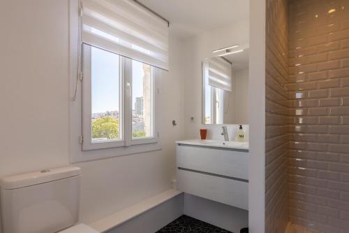 La salle de bains est pourvue de toilettes, d'un lavabo et d'une fenêtre. dans l'établissement Les Séraphines - Chambres d'hôtes - Guests house, à Bordeaux