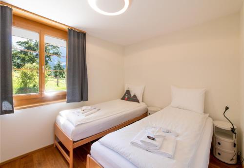a bedroom with two beds and a window at Panoramapark Soleil B Garden Apartment in Wengen