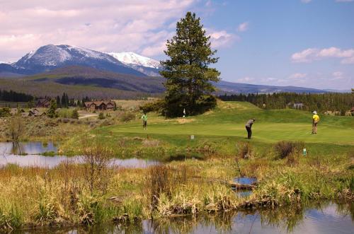 a group of people playing golf on a golf course at The Lodge at Breckenridge in Breckenridge
