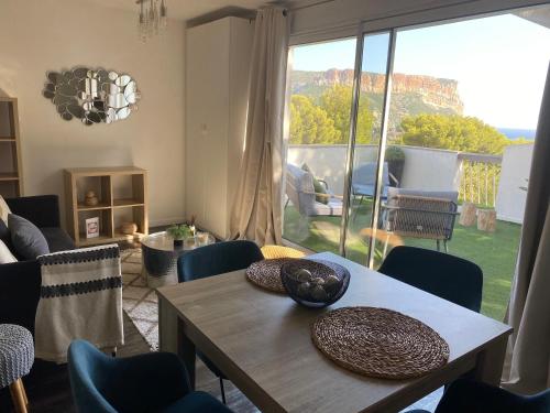 a living room with a table and chairs and a large window at Villa W in Cassis