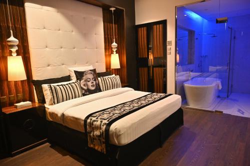 Ista Suites Seef في المنامة: غرفة نوم بسرير كبير وحمام مع حوض استحمام