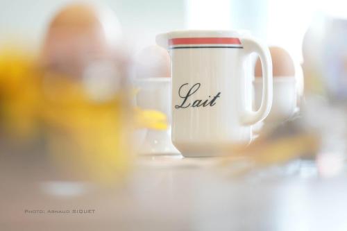 a white cup with the word salt written on it at Gîte familial ferme des aujes falaen in Onhaye