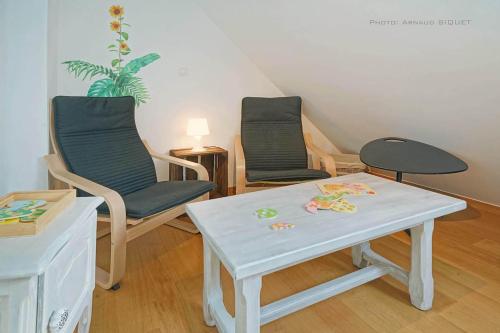 a living room with two chairs and a table at Gîte familial ferme des aujes falaen in Onhaye