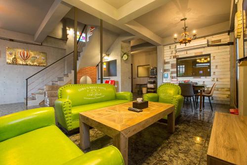 a living room with green furniture and a wooden table at Yi Suo Yen Yu Homestay in Chenggong