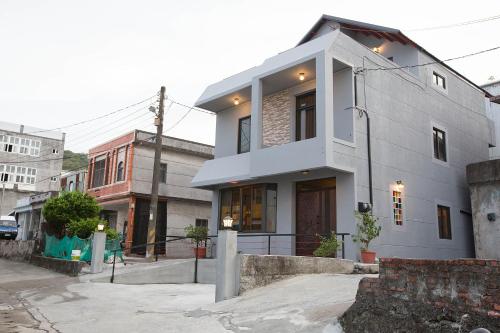 a white house on a city street at Yi Suo Yen Yu Homestay in Chenggong