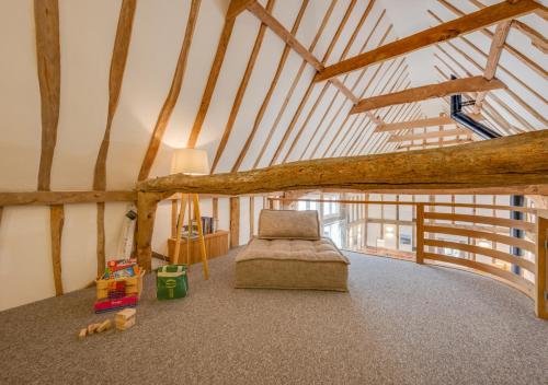 um quarto no sótão com uma cama e um galho de árvore em The Corn Barn em Kersey