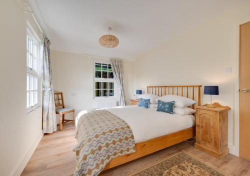 a bedroom with a large bed with blue pillows at Garden Lodge in Worlingworth