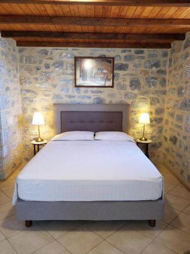een slaapkamer met een bed met twee lampen op twee tafels bij Kyrimi in Yerolimin