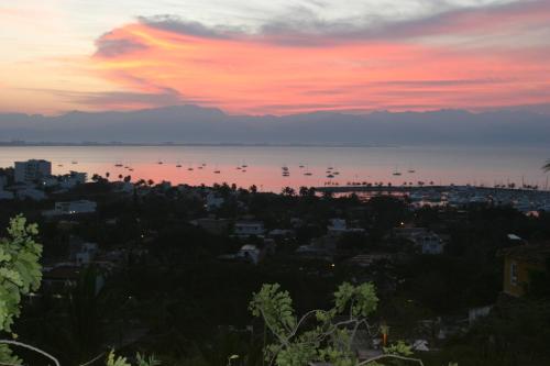 a sunset over a city with boats in the water at Quinta del Encanto in Cruz de Huanacaxtle