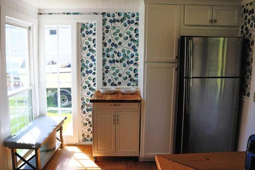 eine Küche mit einem Kühlschrank, einem Tisch und einem Fenster in der Unterkunft Sweet Mary home in Jamestown