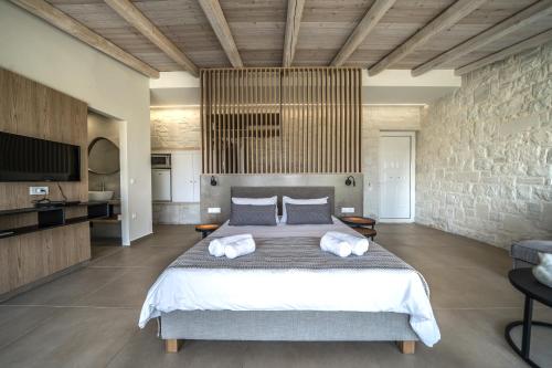 a bedroom with a large bed with two pillows at Lofos Village Chania in Agia Marina Nea Kydonias