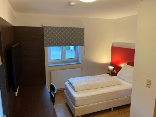 Habitación pequeña con cama y ventana en Gästehaus Linde Salching, en Salching