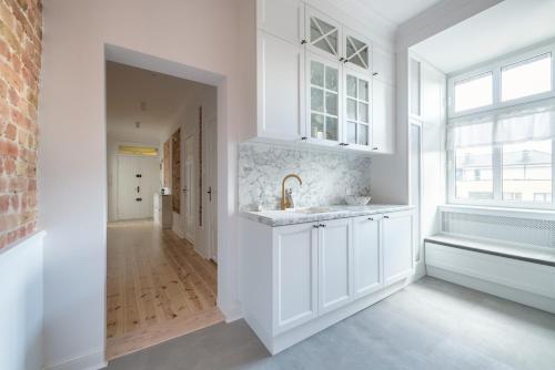 a white kitchen with a sink and a window at Dom & House - Apartment Golden Loft Sopot in Sopot