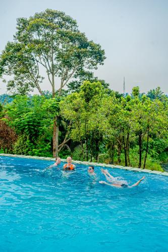 three children swimming in a pool in the water at Hotel Deli River and Restaurant Omlandia in Medan