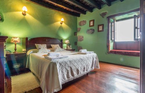 Dormitorio verde con cama y ventana en Casa de Mi Abuela Maria, en La Frontera
