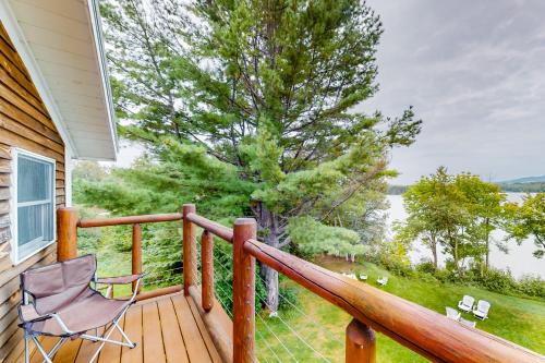 a deck with a chair and a view of the water at East Cove in Greenville