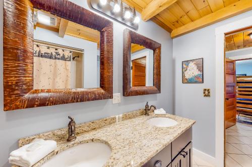 een badkamer met 2 wastafels en 2 spiegels bij East Cove in Greenville