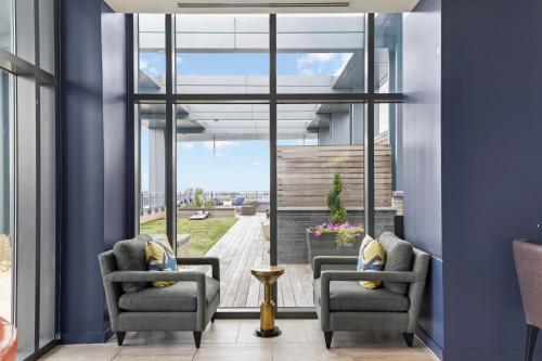 two chairs in a room with large windows at Placemakr Marymount Ballston in Arlington