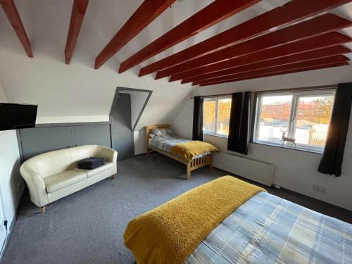 1 Schlafzimmer mit 2 Betten, einem TV und Fenstern in der Unterkunft Self Catering Spacious open plan 3 bed apartment with sea views in South Erradale