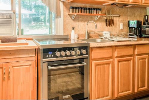 een keuken met een fornuis en een wastafel bij Pocono cabin with private pool at Shawnee Mtn in East Stroudsburg