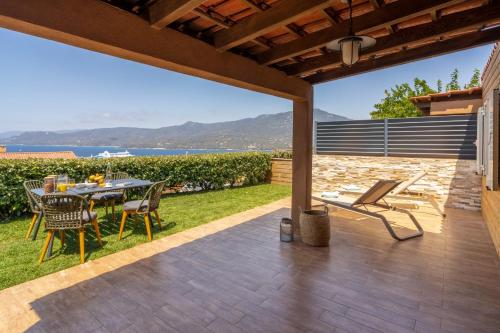 a patio with a table and chairs and a view of the ocean at Résidence U Frusteru in Propriano