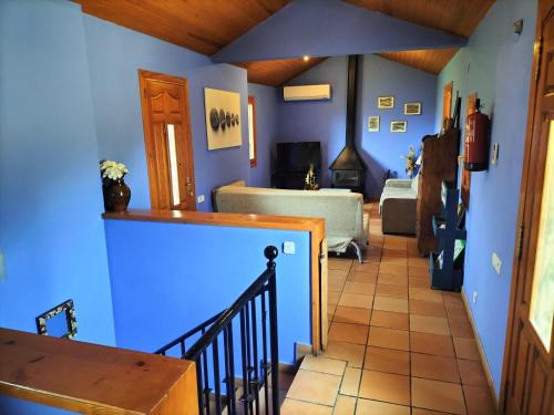 d'un salon avec des murs bleus et un escalier. dans l'établissement LA VIÑAZA ORDESA 4-6 PAX, à Laspuña