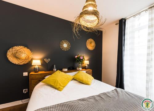 - une chambre avec un lit et des oreillers jaunes dans l'établissement Les Gîtes du château - 2 Magnifiques Appartements face au château Henri IV, à Nérac