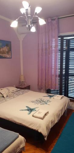 a bedroom with two beds and a ceiling fan at Guest House Cinderella in Herceg-Novi