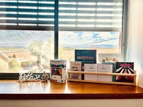 a window with books on a shelf in front of a window at הפינה של טלי בנהריה - יחידות אירוח וספא בריאות in Nahariyya