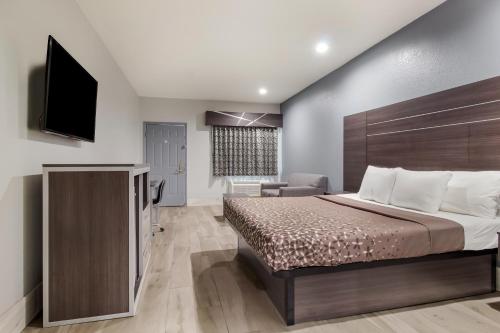 a hotel room with a bed and a television at Americas Best Value Platinum Inn & Suites in Houston