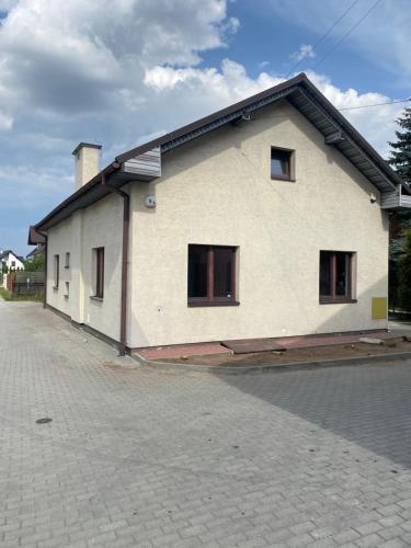 a white house with windows on a brick road at Dom #BESKIDZKA in Rzeszów