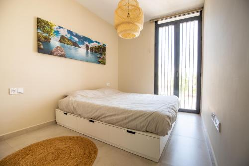 1 dormitorio con cama y ventana grande en Luxe nieuwbouw penthouse op 600 m van het strand!, en Los Nietos