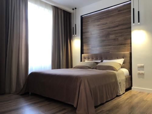 a bedroom with a large bed and a large window at CarpHouse in Bălţi