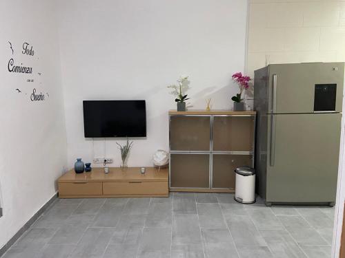 ein Wohnzimmer mit einem Kühlschrank und einem TV in der Unterkunft piso acogedor con encanto in Navas del Rey