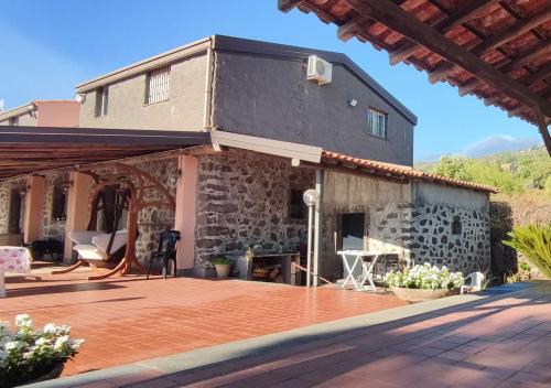 une maison avec une terrasse en face de celle-ci dans l'établissement Peri Peri Etna Guest House, à Montargano