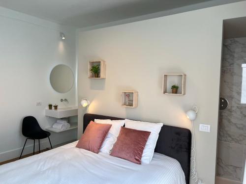a bedroom with a white bed with two pillows at Tuss in Kortrijk