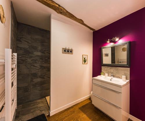 a bathroom with purple walls and a sink at Les Gîtes du château - 2 Magnifiques Appartements face au château Henri IV in Nérac