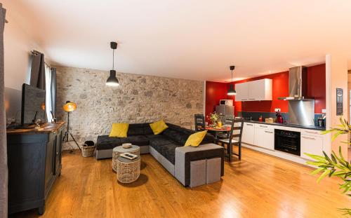 un salon avec un canapé et une cuisine dans l'établissement Les Gîtes du château - 2 Magnifiques Appartements face au château Henri IV, à Nérac