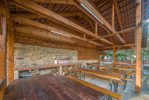 a large room with wooden tables and benches at Lipicai Ifjúsági Szálló in Szilvásvárad