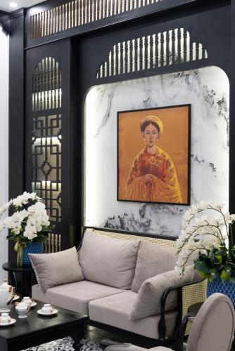 a living room with a couch and a painting on a wall at Thuy Duong Boutique Hotel Hue in Hue