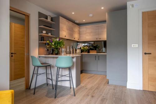 a kitchen with a bar and two stools at The Quadrant - The Ruskin Suite in York